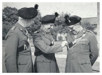 Lieutenant General Sir Ian Harris, Colonel of the new Regiment introduces the Deputy Colonels Major General Pat Scott and Major General Harry Grimshaw to the intricacies of wearing a cross belt.