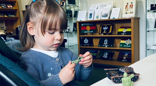 girl in blue dress playing with a toy